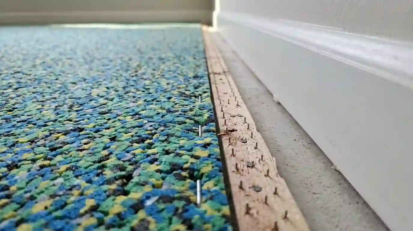 New carpet pad and tack strip installed along a wall